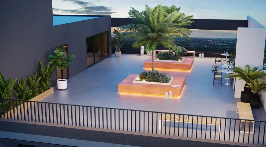 Lounge do rooftop do Liv Sintonia ao entardecer, com palmeiras e jardineiras iluminadas